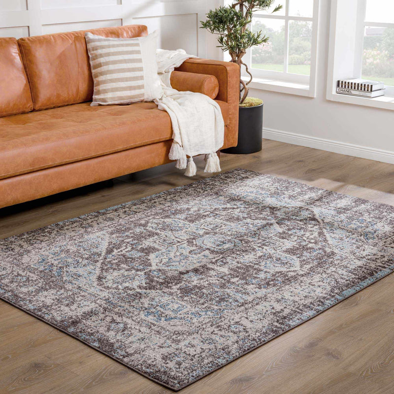 Dark brown medallion area rug by Hauteloom, shown in a room scene with intricate pattern and plush texture.