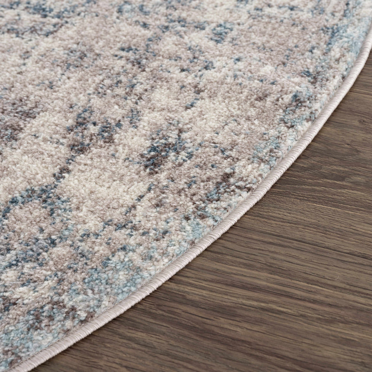 Corner view of Hauteloom Orrick area rug with intricate patterns and warm colors in a stylish living room setting.