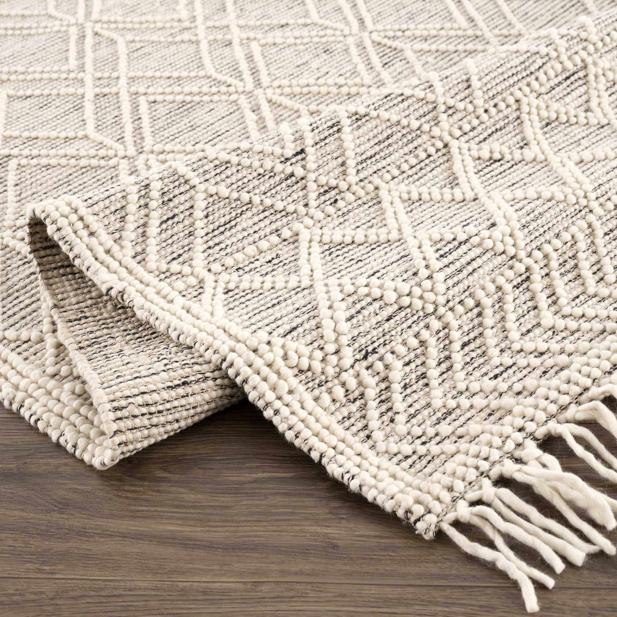 Hauteloom Ramsbury area rug folded with geometric pattern in neutral tones, suitable for living room or bedroom decor.