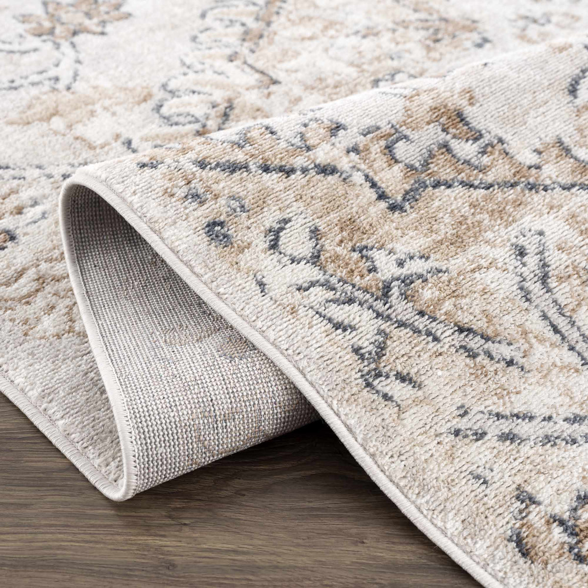 Hauteloom Mudgee Area Rug with folded edges, showcasing intricate patterns and soft texture in a stylish living room setting.