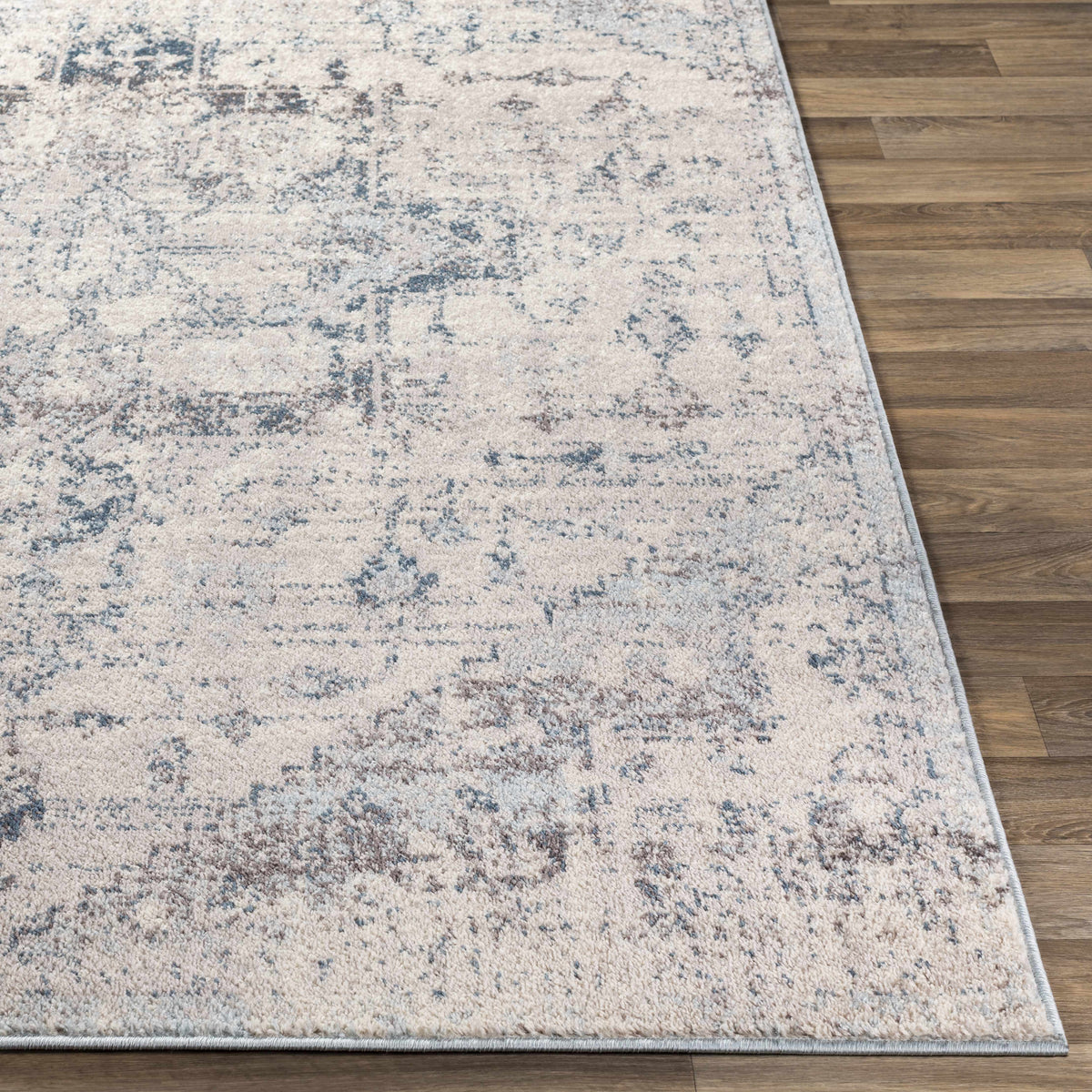 Hauteloom Orrick area rug with intricate geometric patterns in neutral tones, displayed flat on a hardwood floor.