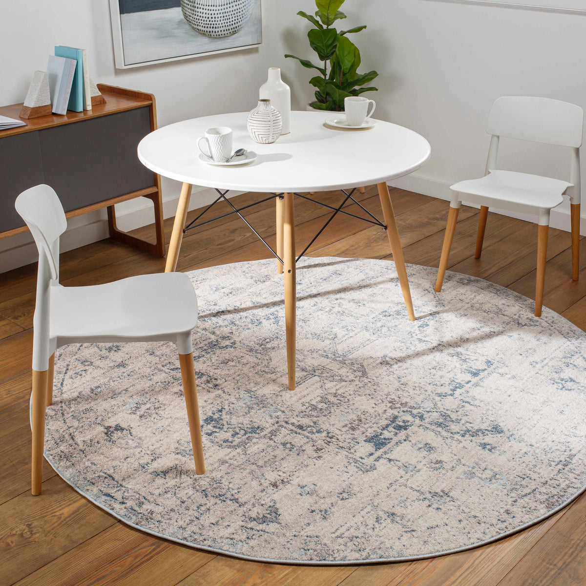 Round Hauteloom Orrick area rug with intricate patterns, shown in a cozy room setting with furniture and decor.