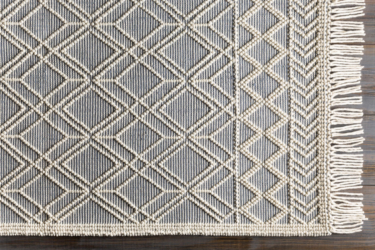 Overhead view of Hauteloom Ramsbury Ivory and Blue area rug with intricate geometric patterns on a neutral background.