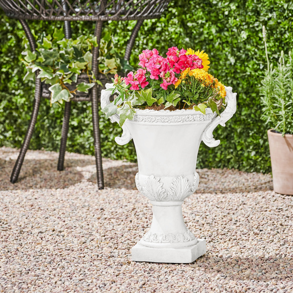 Roman style MGO garden urn planter with drainage hole in antique white finish, ideal for outdoor floral displays.
