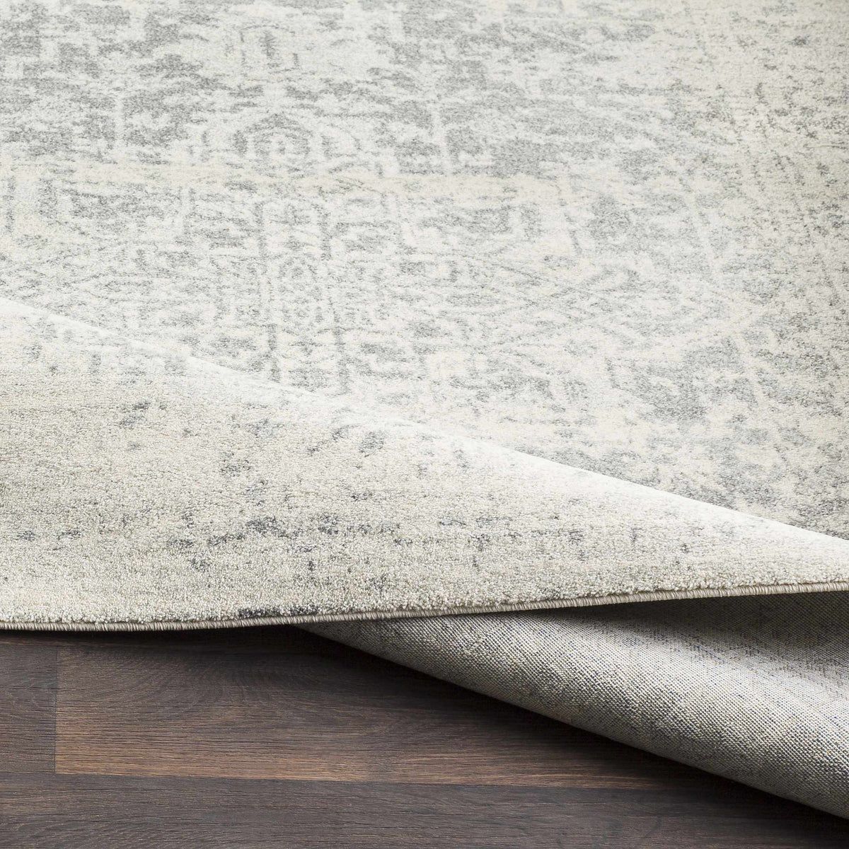 Hauteloom Rachel area rug with geometric patterns in neutral tones, shown folded for display.
